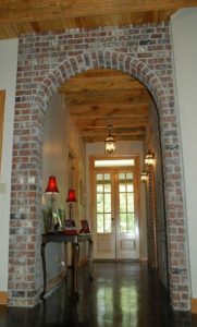 Entry hall with exposed brick by Eby's Drafting and Design